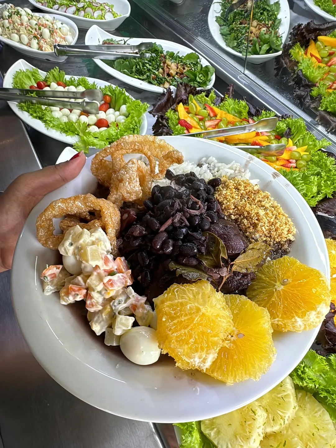 Prato de cortes de carne com farofa e acompanhamentos