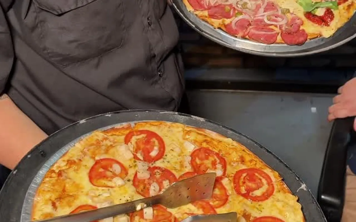 Pizza gourmet da Pizza Gyn com o queijo puxando