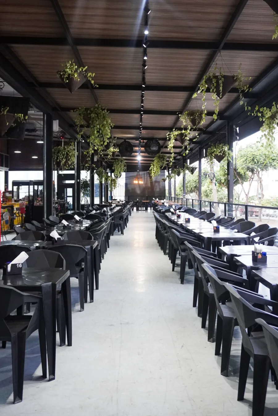 Salão amplo da Pizza Gyn com mesas e plantas suspensas