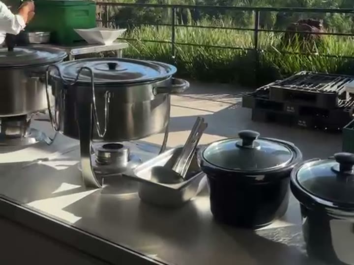 Panelas de ferro de caldo fumegante na bancada da estação ao ar livre da Pizza Gyn
