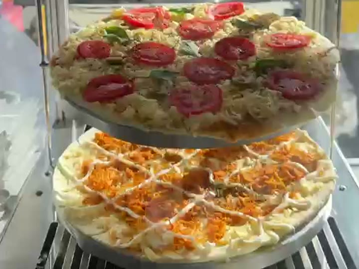 Pizzas da Pizza Gyn saindo quentinhas na estufa giratória, com tomate e cobertura derretendo