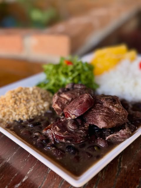 Prato de feijoada completa com arroz, farofa e couve