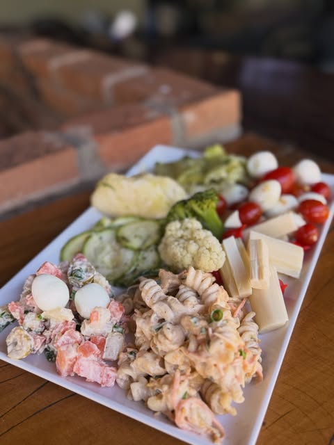 Tábua de saladas, frios e legumes variados servidos no buffet